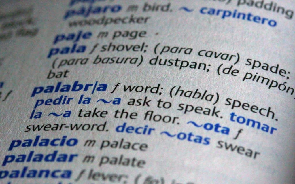 An open Spanish dictionary displaying the work 'palabra' and its English translation, 'word'.