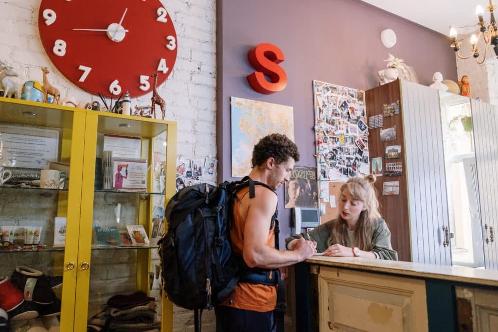 A backpacker checks in at a hostel reception desk. It accompanies one of our tips for backpackers in South America.