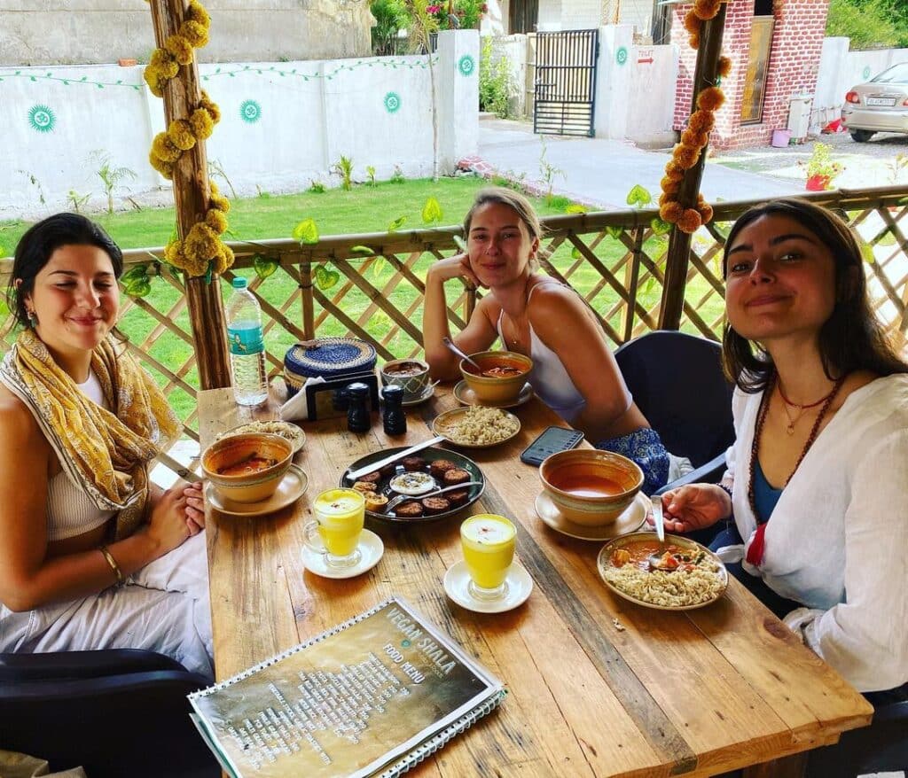 Picture of beautiful ladies enjoying the meals in Vegan Shala eatery. One of the 10 best places for vegan food in Rishikesh.