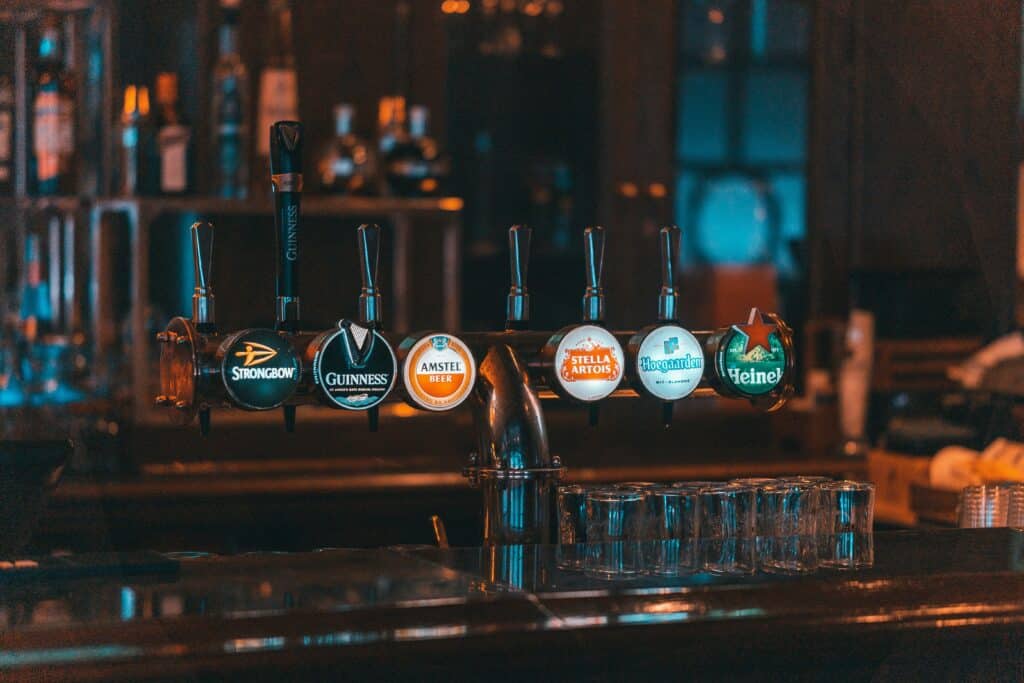 A mesmerizing selection of unique beer taps, each one representing the diverse drinking culture of pub in Lagos. Indulge in the vibrant flavors and rich history of local brews and immerse yourself in the captivating atmosphere of this bustling city.