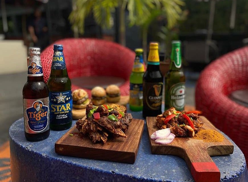 A traditional Nigerian cuisine, expertly paired with a refreshing local beer, soak up the lively atmosphere of one of the bustling pubs in Lagos. 