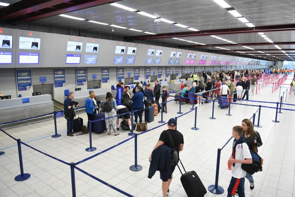 Travelers at the airport check-in counter, eagerly awaiting their turn to board, highlighting the privilege of passport as they prepare to embark on their journey to new destinations around the world.