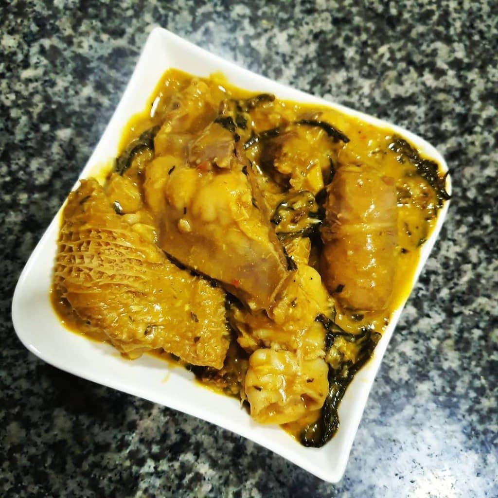 An appetizing bowl filled with Bitter Leaf Soup, a traditional Nigerian delicacy made with bitter leaves, assorted meats, and flavorful spices, served with a side of fufu.