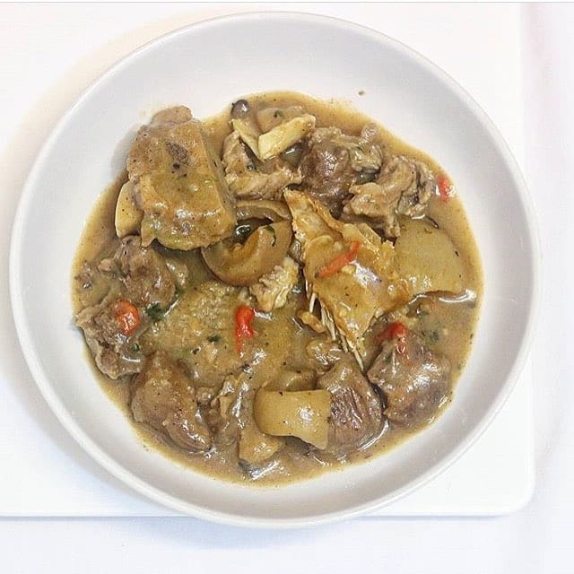 An image showcasing a bowl of White Soup, a traditional Nigerian delicacy. The soup is creamy in texture with visible chunks of assorted meats and fish.