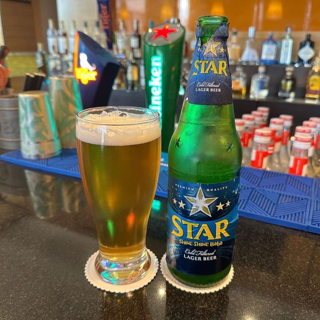 A bottle and glass of Star beer, one of the best Nigerian beers, placed on a table, showcasing its refreshing appearance and inviting presentation.