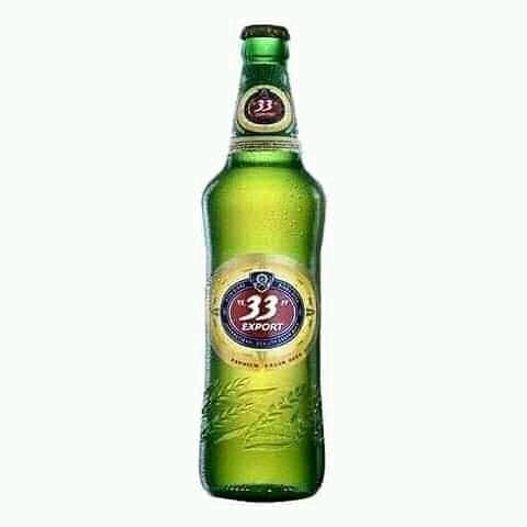 A green bottle of 33 Export Lager beer, a popular Nigerian brew.